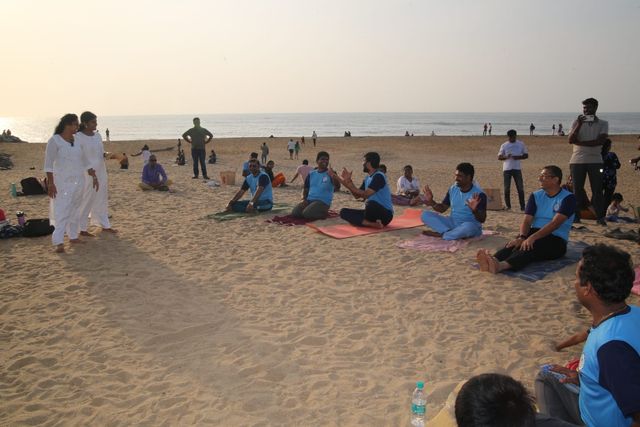Members of the men's group sitting together on the sand at the beach session