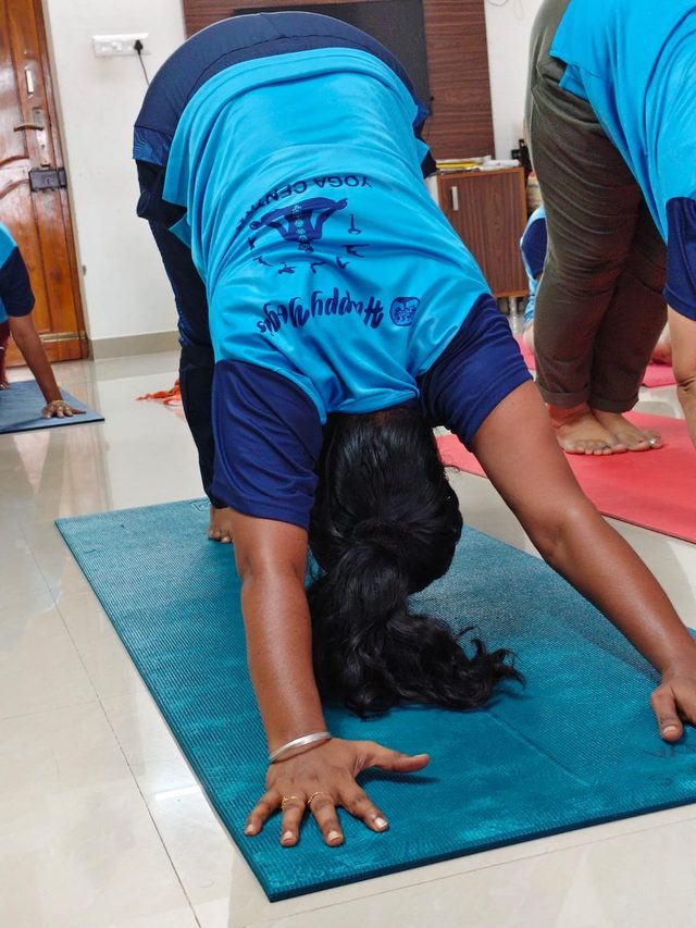 Student holding downward dog on a mat at the centre