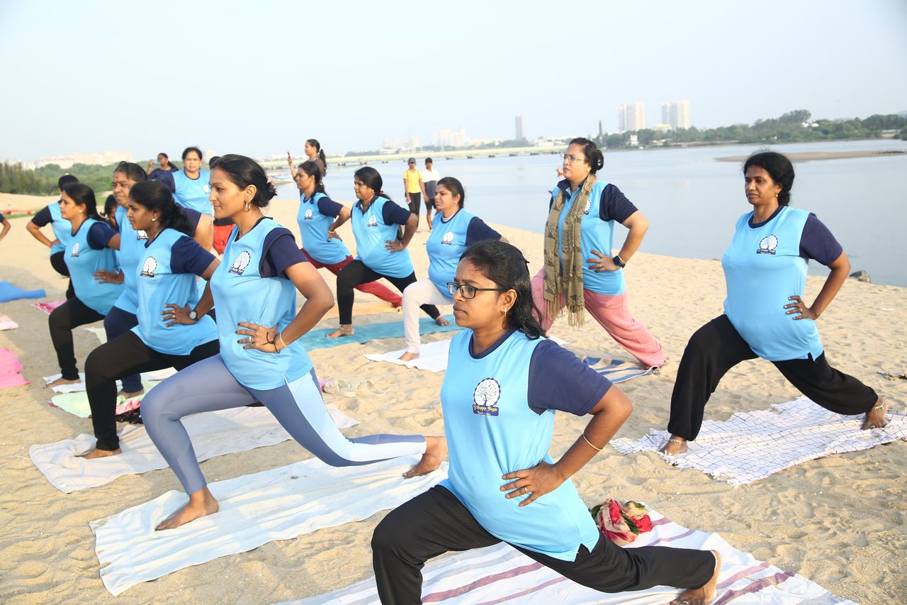 Students holding a low lunge together, the backwater behind them