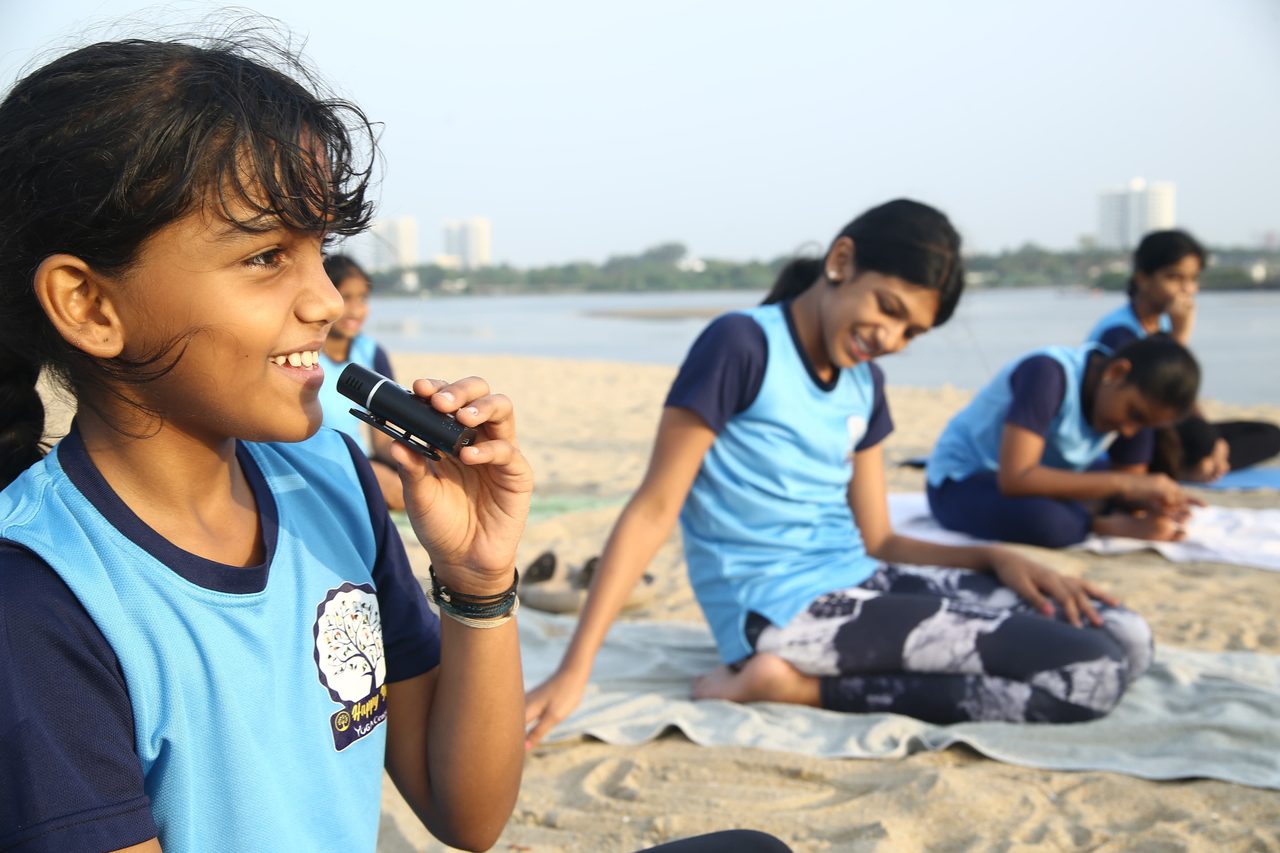 A young student speaking into a microphone at the beach session
