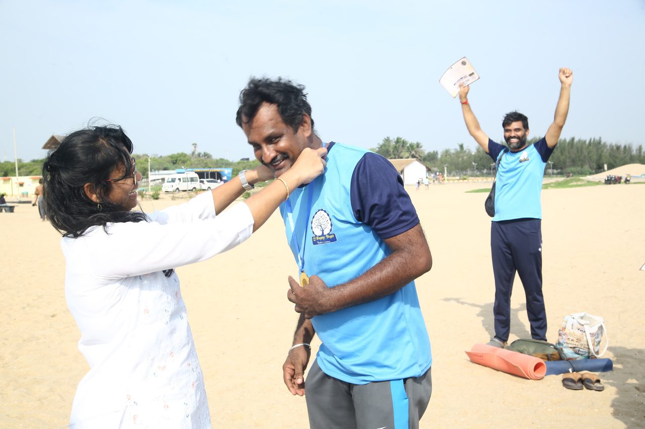 A finisher receiving his medal while another celebrates behind him