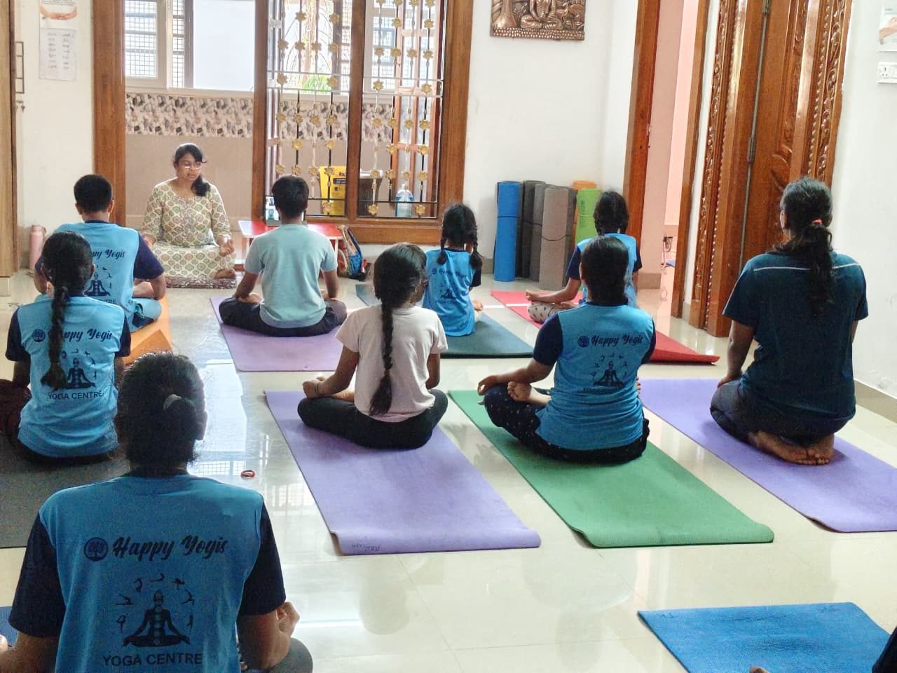 Teacher leading a seated breathing practice for a mixed-age group